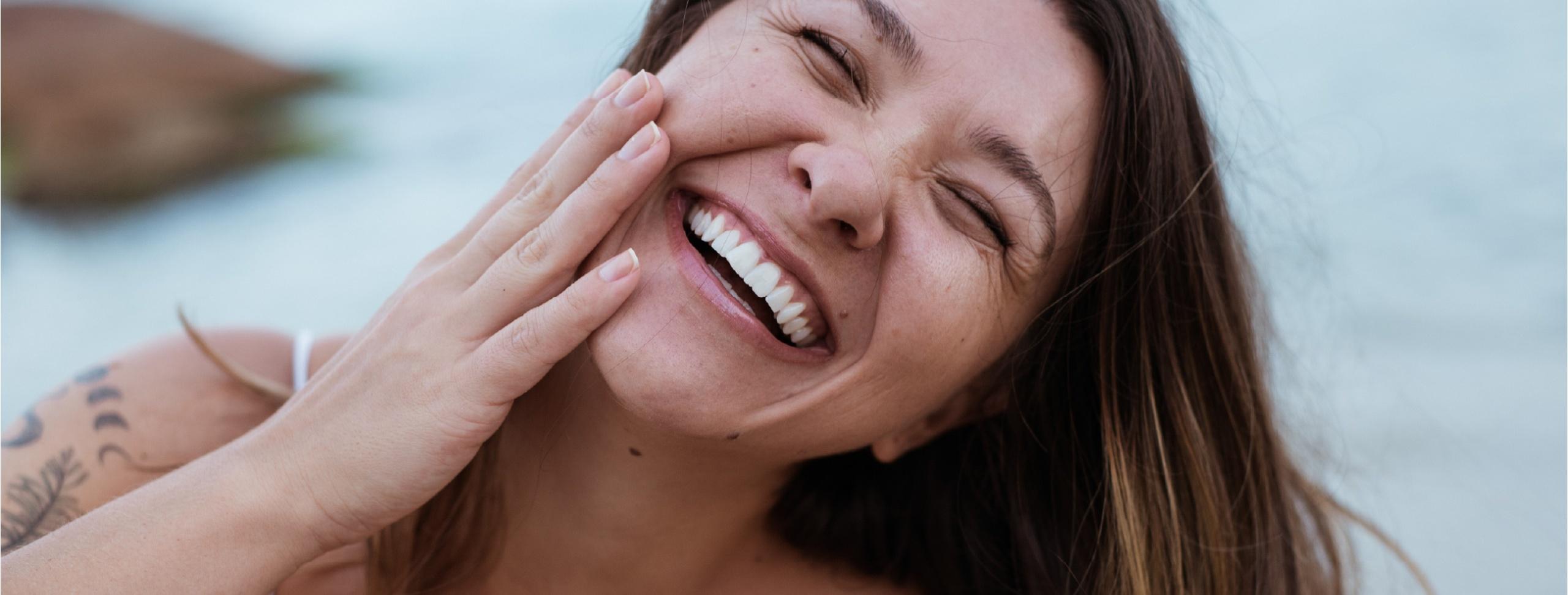 Pessoa sorrindo durante seu ritual de skincare